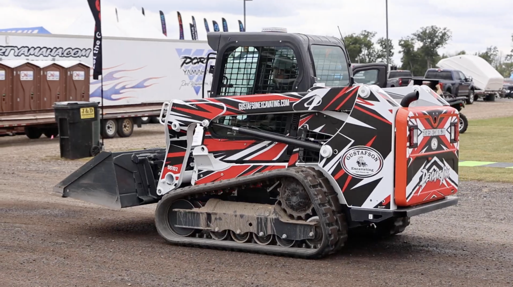Bobcat T550 compact track loader wrapped in Sledder One design by Deviant Ink, featuring bold black and white sled-style graphics